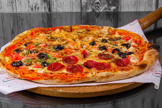 Frisch gebackene Pizza mit Salami, Oliven und Gemüse auf Holzbrett serviert